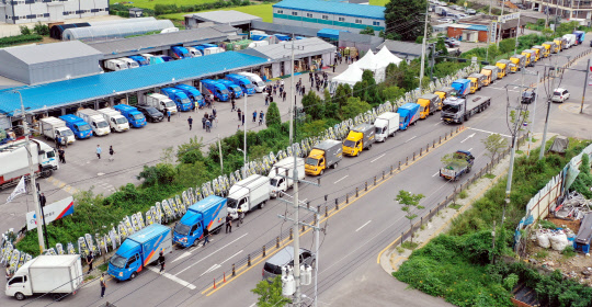 2일 오전 경기도 김포시 한 택배업체 터미널 인근 도로에 40대 택배대리점주 A씨를 추모하는 택배차량이 줄지어 정차돼 있다. A씨는 노조를 원망하는 내용의 유서를 남기고 지난달 30일 극단적 선택을 했다. <김포=연합뉴스>
